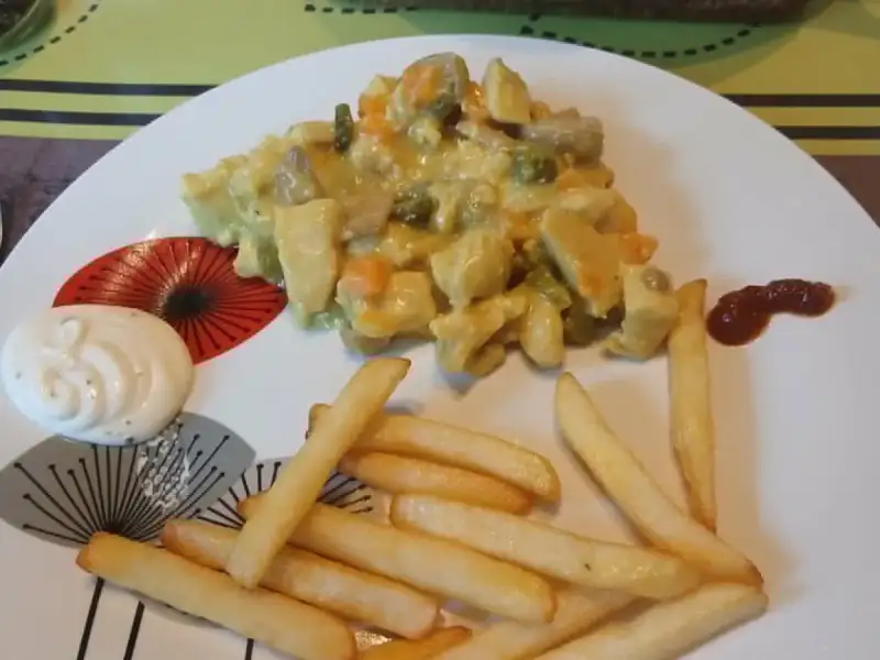 Vol-au-vent minute au poulet, champignons, carottes et petits pois en sauce au curcuma, servi avec des frites et de la mayonnaise